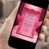 Save the Date Digital Victoria's Secret exibido em celular, com moldura rosa ornamentada, asas decorativas e visual inspirado no universo glamouroso.