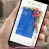 Capa do Convite de 15 Anos Mamma Mia inspirada no charme das ilhas gregas. O design apresenta uma tradicional janela azul vibrante cercada por flores coloridas sobre um fundo branco iluminado, transmitindo leveza, romantismo e a atmosfera mediterrânea característica do tema. A composição delicada cria uma experiência visual elegante e acolhedora para anunciar uma celebração inesquecível.